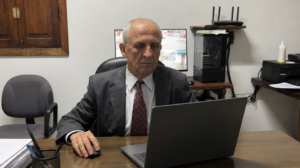 Dr. Gilvandi, advogado tributarista, calculando prazos de parcelamento e prescrição de IPTU no notebook