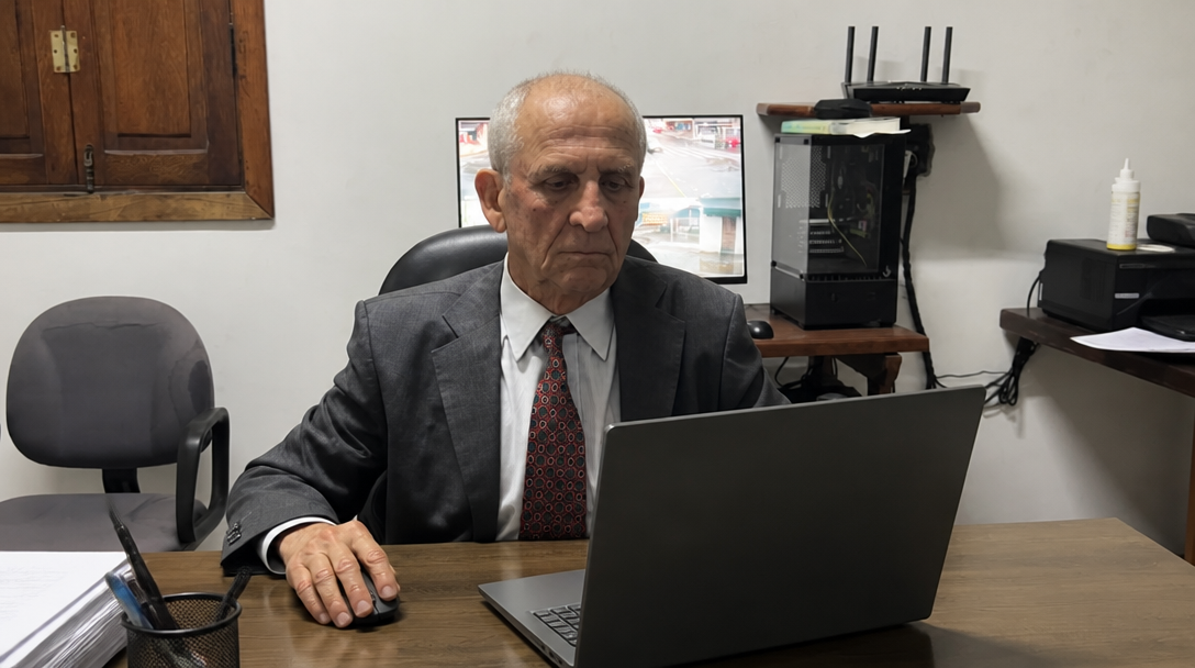 Dr. Gilvandi, advogado tributarista, calculando prazos de parcelamento e prescrição de IPTU no notebook